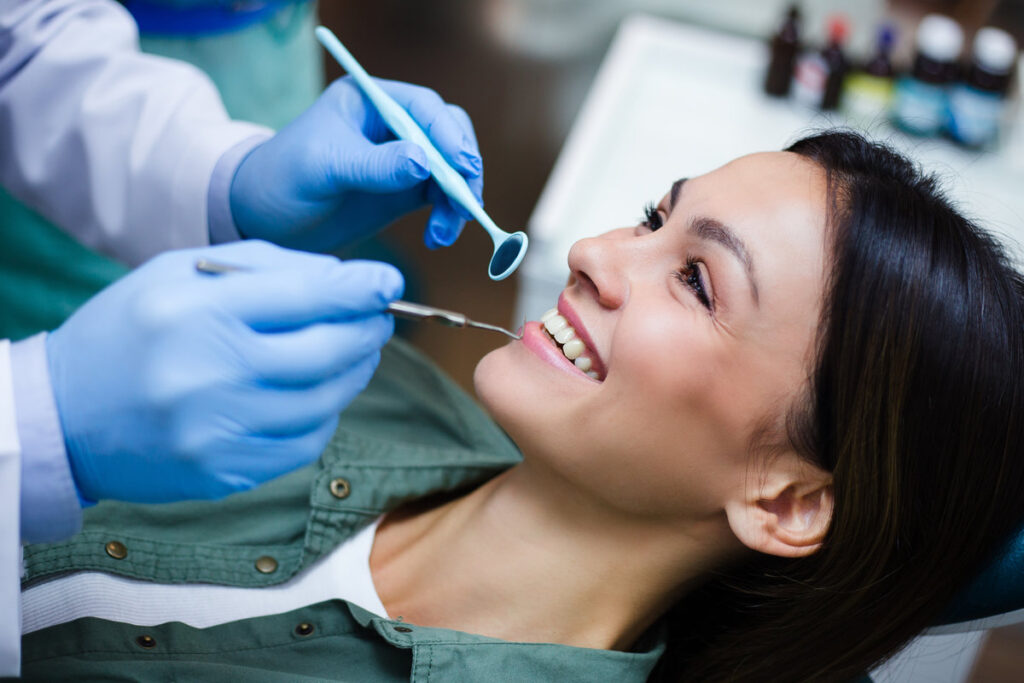 Her stunning smile! Close-up of dentist examining his beautiful patient in dentist’s office