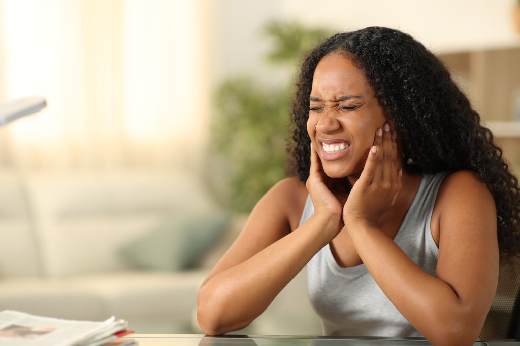 Black woman suffering tmj complaining sitting at home