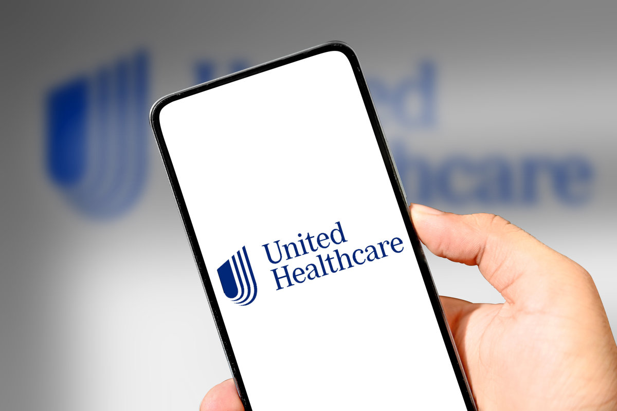 United Healthcare Mobile application concept with smartphone in hand, illustrative editorial. Top healthcare company editorial backdrop