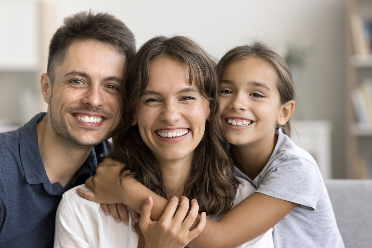 Authentic beautiful Latin parents and daughter smiling revealing white teeth advertise professional dental clinic services, medical insurance cover for young families, close up portrait. Ties, love