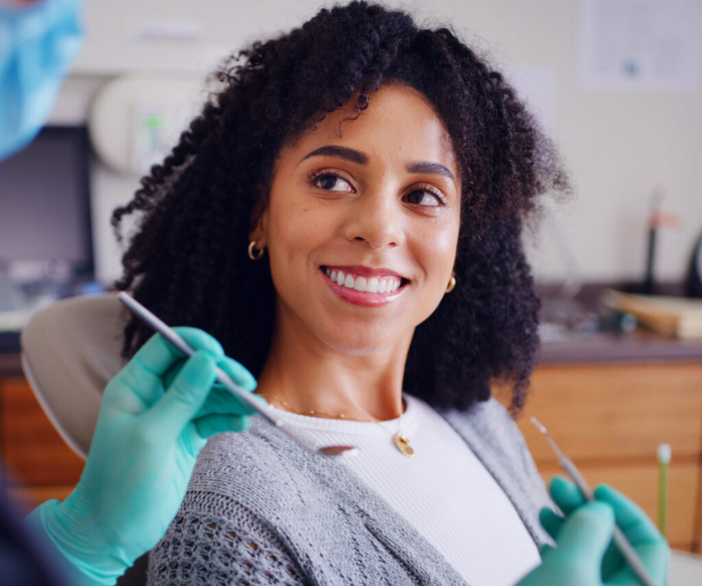 Young female dentist showing the paper to a satisfied smiling bearded man client of the dental office. People talking and looking at each other. People, medicine, stomatology and health care concept