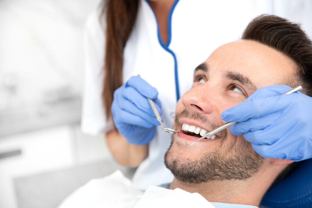 Man having teeth examined at dentists. Overview of dental caries prevention