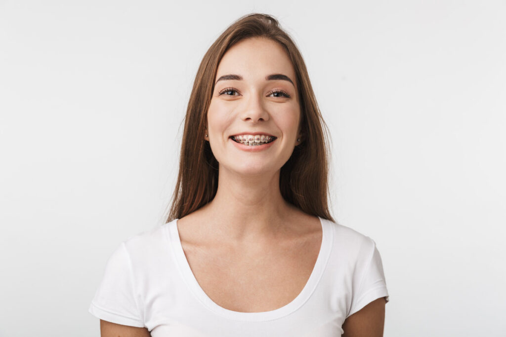 Attractive young woman standing isolated over white background, laughing